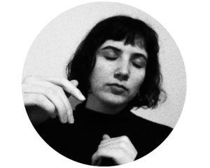 Portrait en noir et blanc de Laurence. Elle a les cheveux foncés coupés au carré. Ses yeux sont fermés et ses mains à la hauteur des épaules suggèrent qu'elle danse calmement.